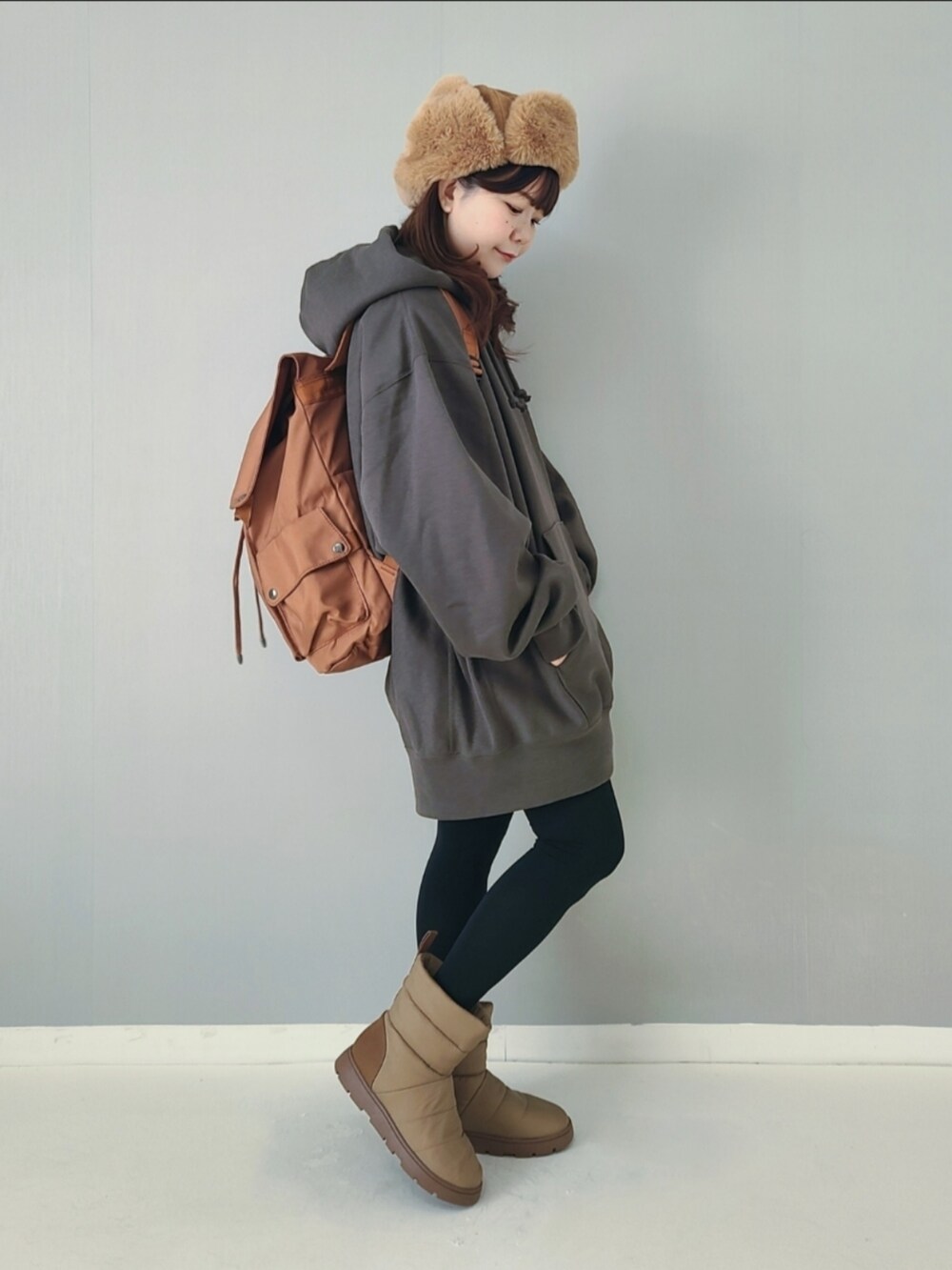 ブラウン系のバックパック/リュック、グリーン系のパーカー、ベージュ系のブーツを着用したレディースの秋コーディネートの2枚目の写真