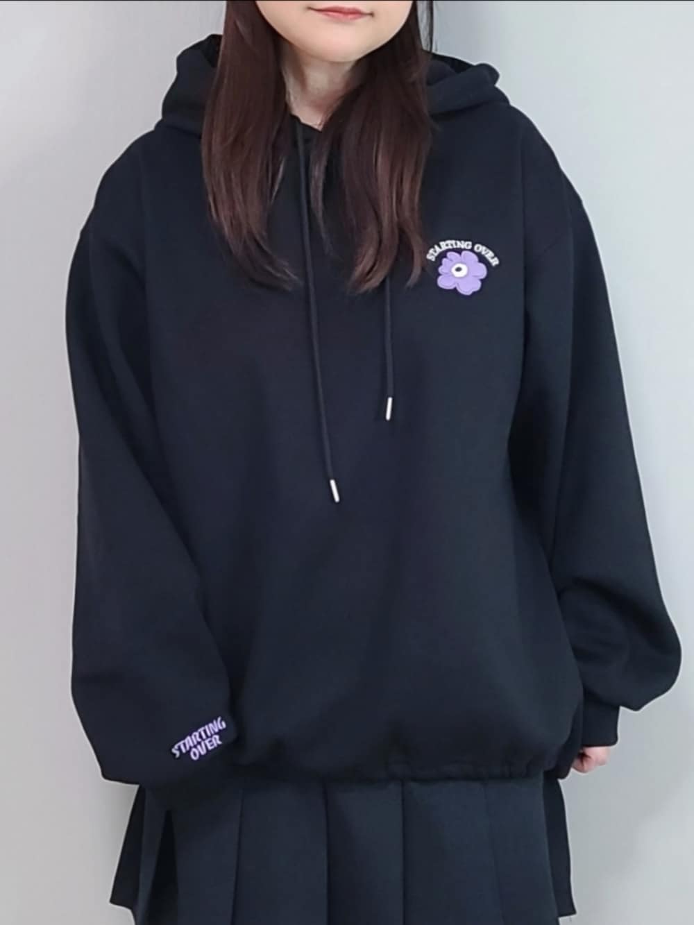 ブラック系のパーカー、ブラック系のスカートを着用したレディースの冬コーディネートの5枚目の写真