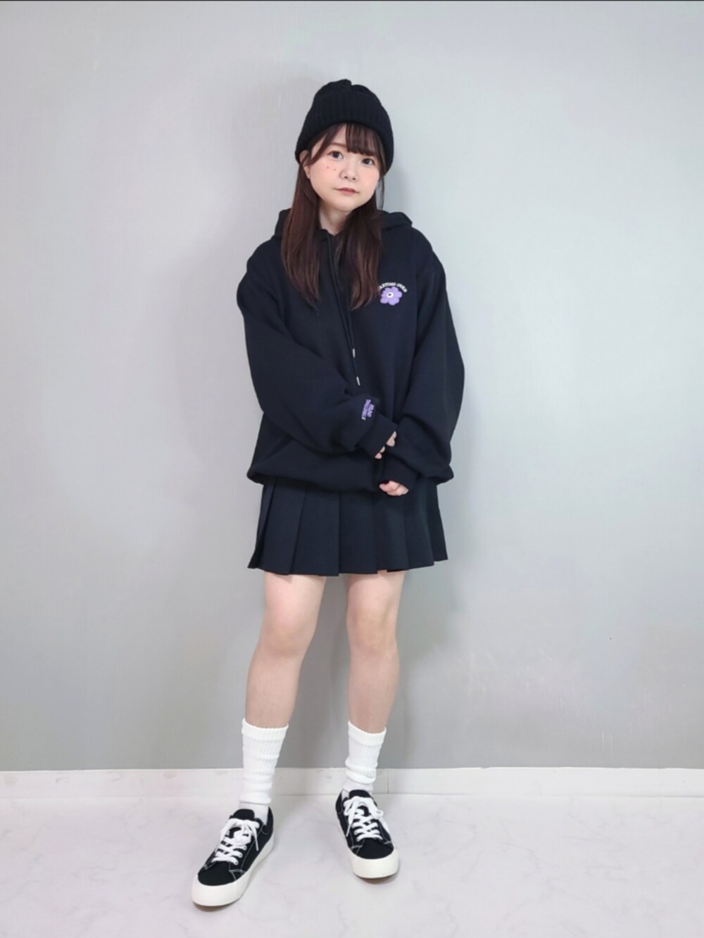 ブラック系のパーカー、ブラック系のスカートを着用したレディースの冬コーディネートの2枚目の写真