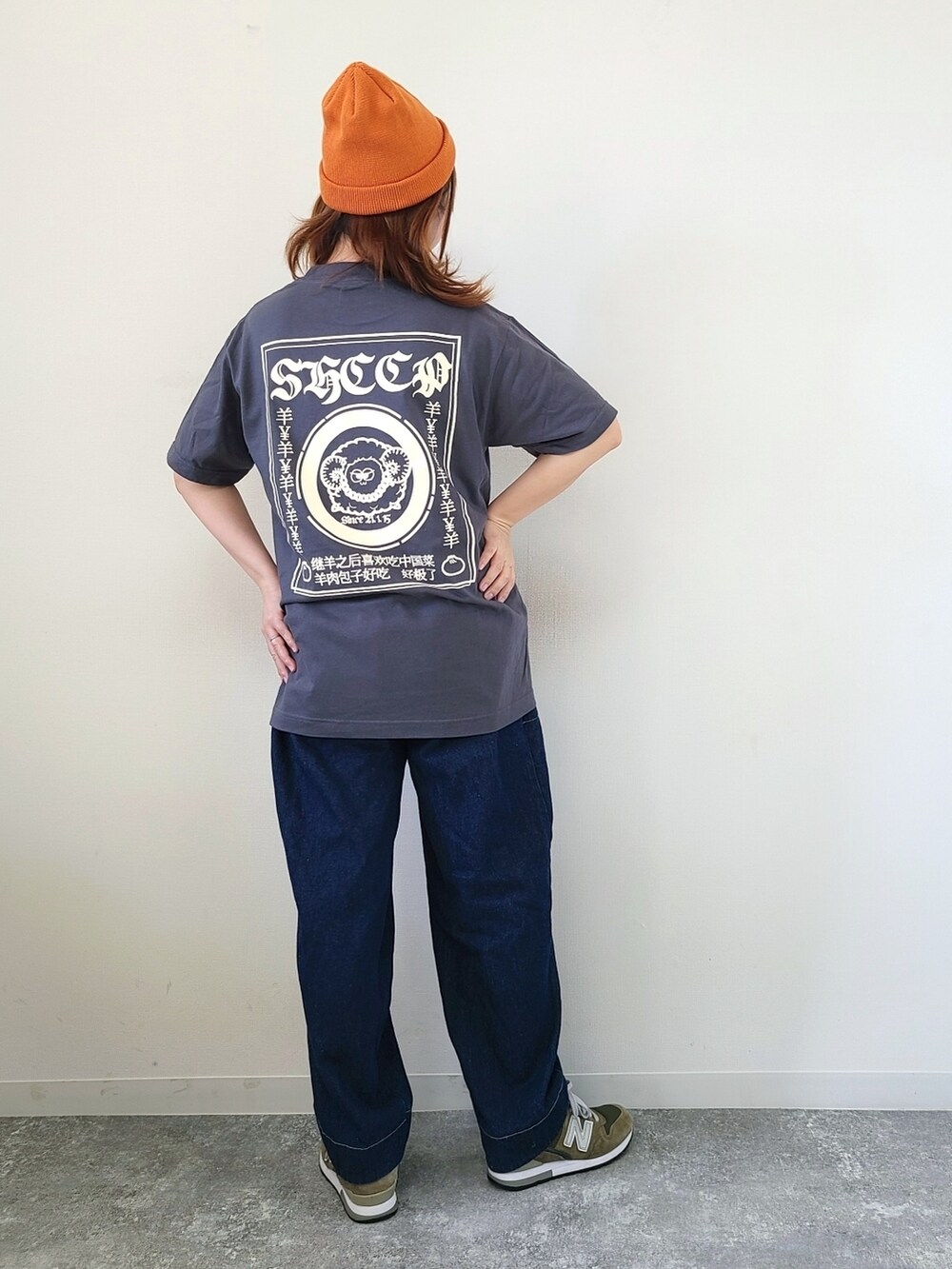 グレー系のTシャツ/カットソー、ブルー系のデニムパンツ、グリーン系のスニーカーを着用したレディースの秋コーディネートの2枚目の写真