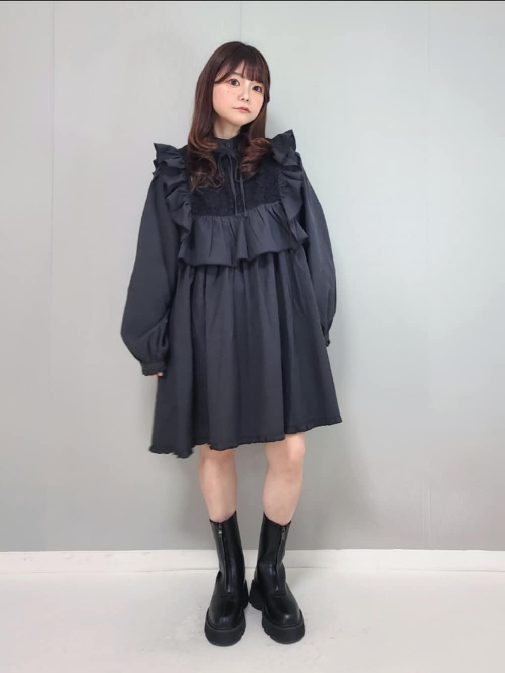 ブラック系のワンピース、ブラック系のブーツを着用したレディースの冬コーディネートの3枚目の写真