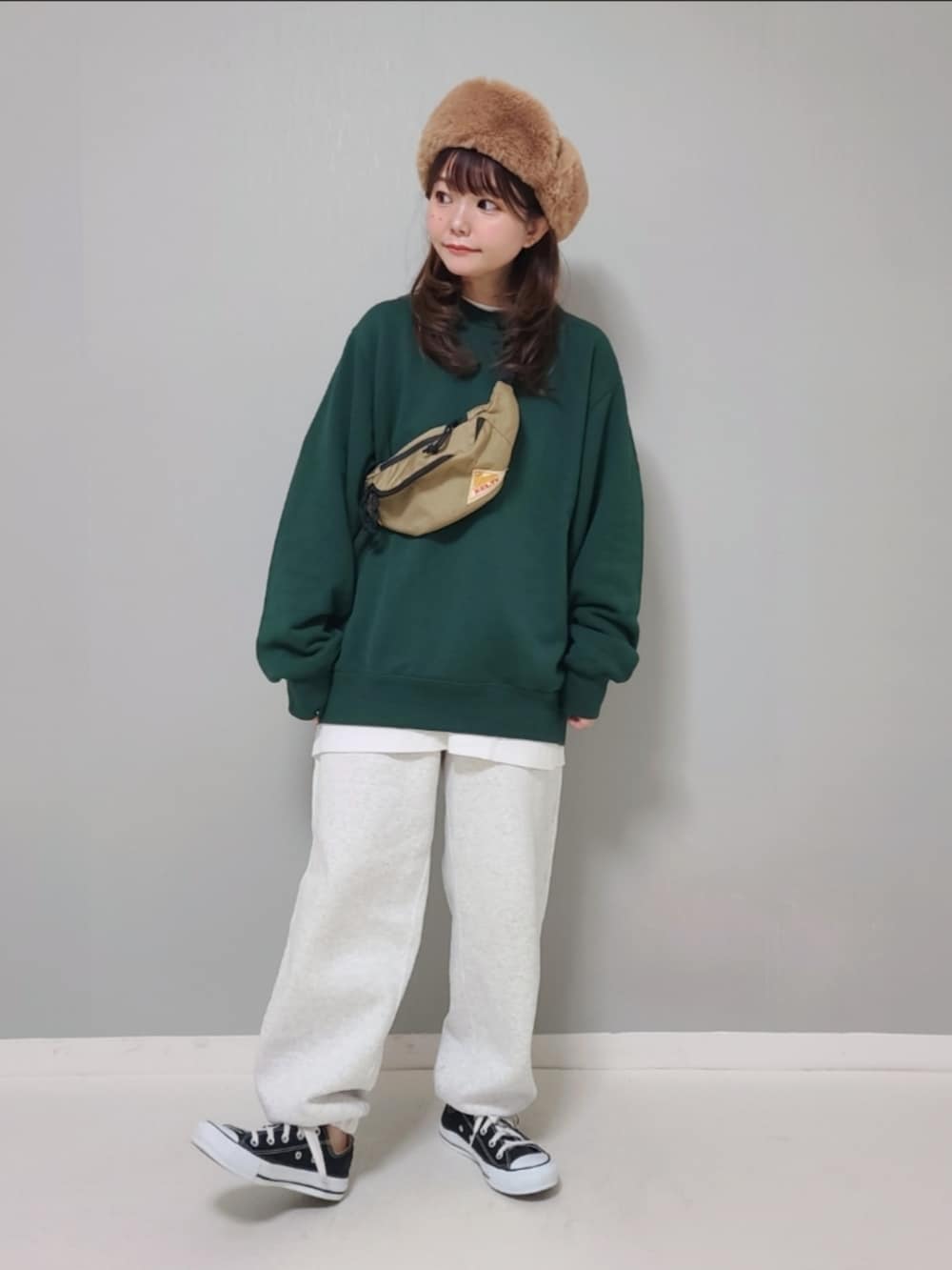 グリーン系のスウェット、ホワイト系のTシャツ/カットソー、グレー系のスウェットパンツを着用したレディースの冬コーディネートの3枚目の写真