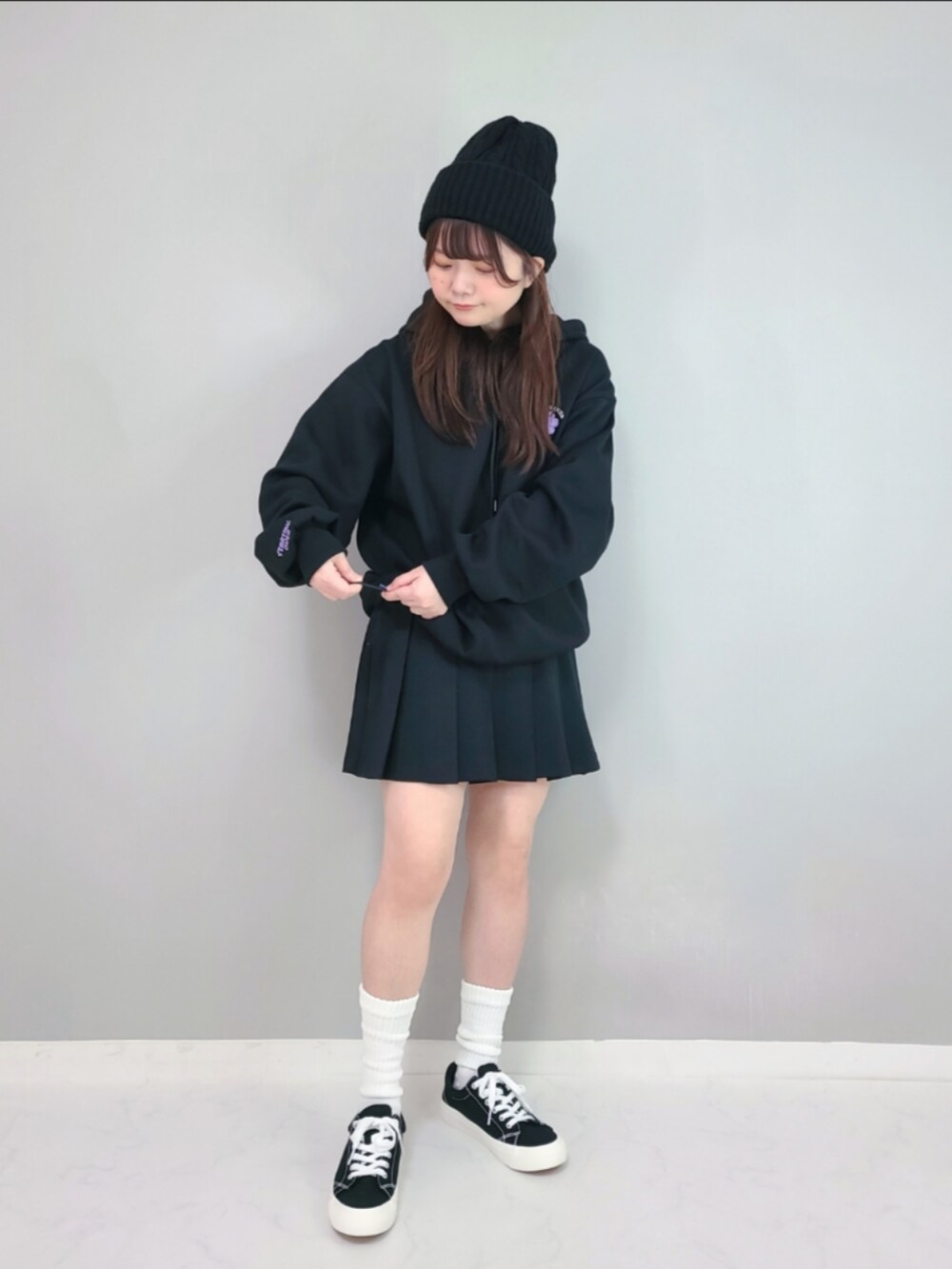 ブラック系のパーカー、ブラック系のスカートを着用したレディースの冬コーディネートの3枚目の写真