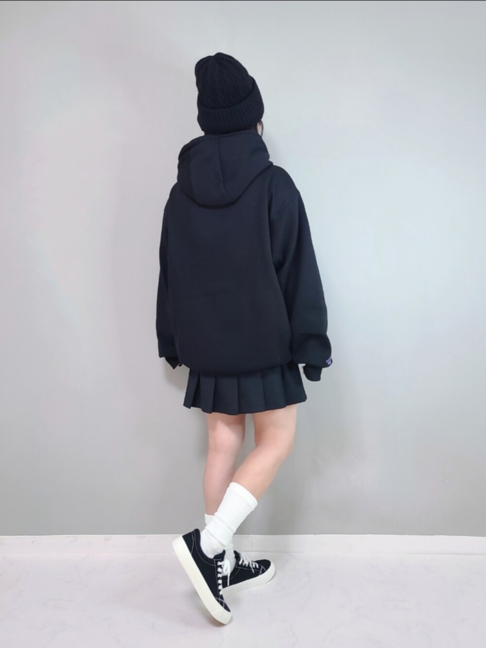 ブラック系のパーカー、ブラック系のスカートを着用したレディースの冬コーディネートの4枚目の写真