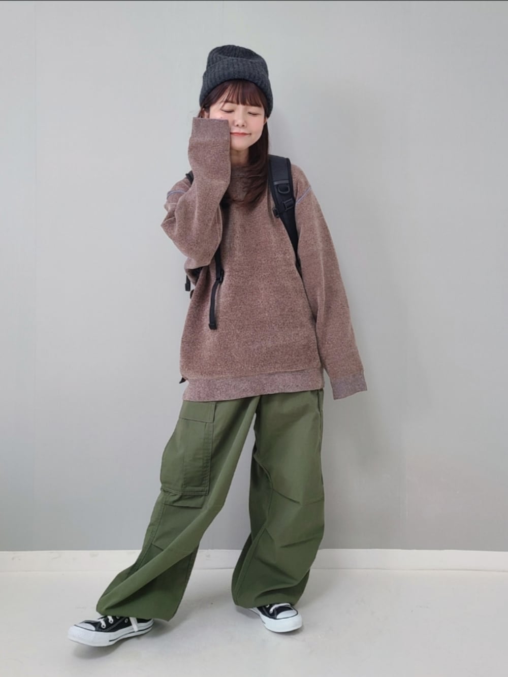 ブラウン系のニット/セーター、グリーン系のカーゴパンツ、ブラック系のスニーカーを着用したレディースの秋コーディネートの2枚目の写真