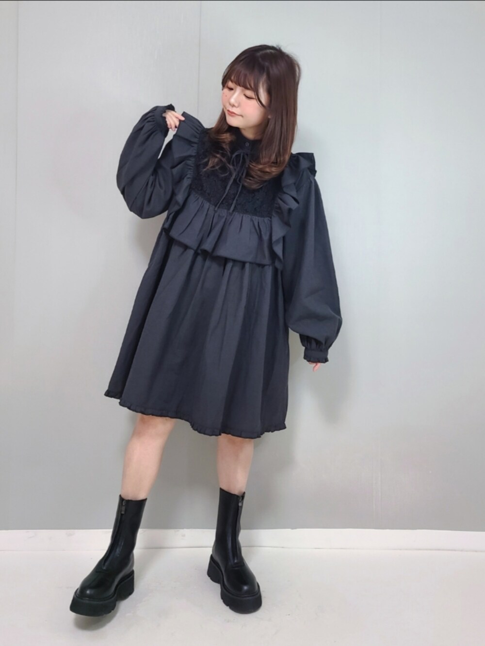 ブラック系のワンピース、ブラック系のブーツを着用したレディースの冬コーディネートの2枚目の写真