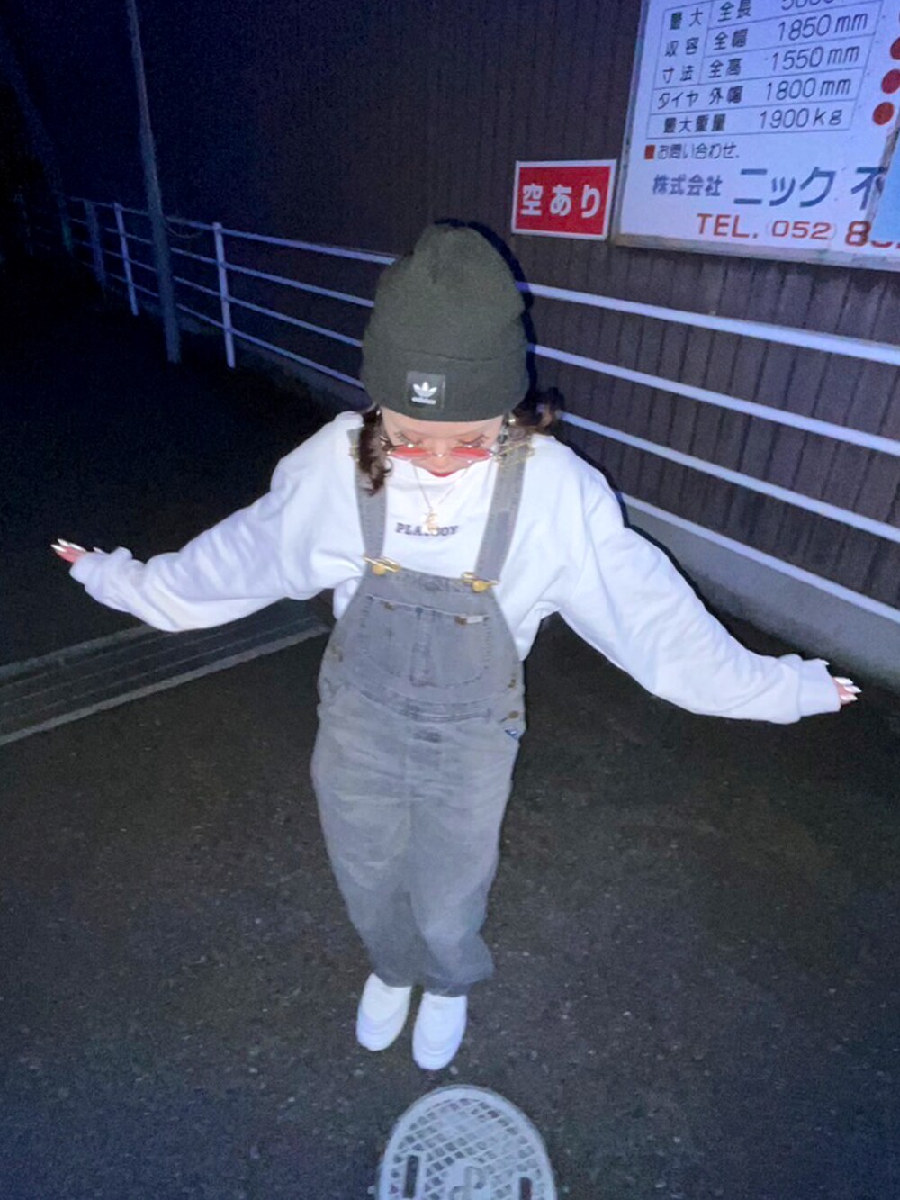 ホワイト系のスウェット、ブラック系のサロペット/オーバーオール、ホワイト系のスニーカーを着用したレディースの冬コーディネートの3枚目の写真