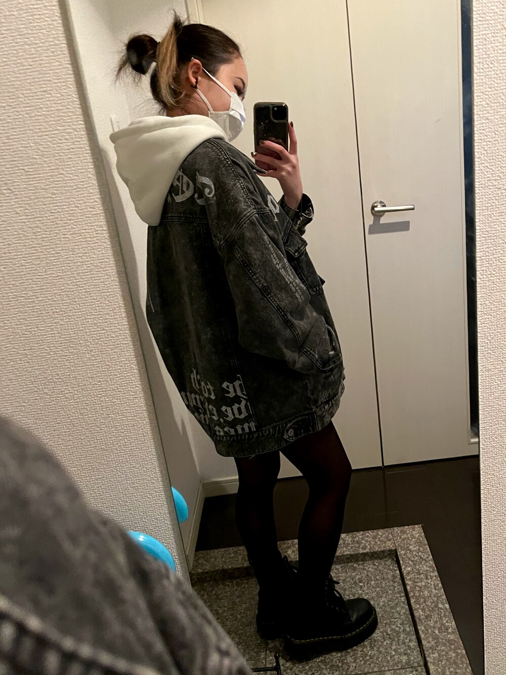 ブラック系のデニムジャケット、ブラック系のトートバッグ、ブラック系のブーツを着用したレディースの秋コーディネートの2枚目の写真