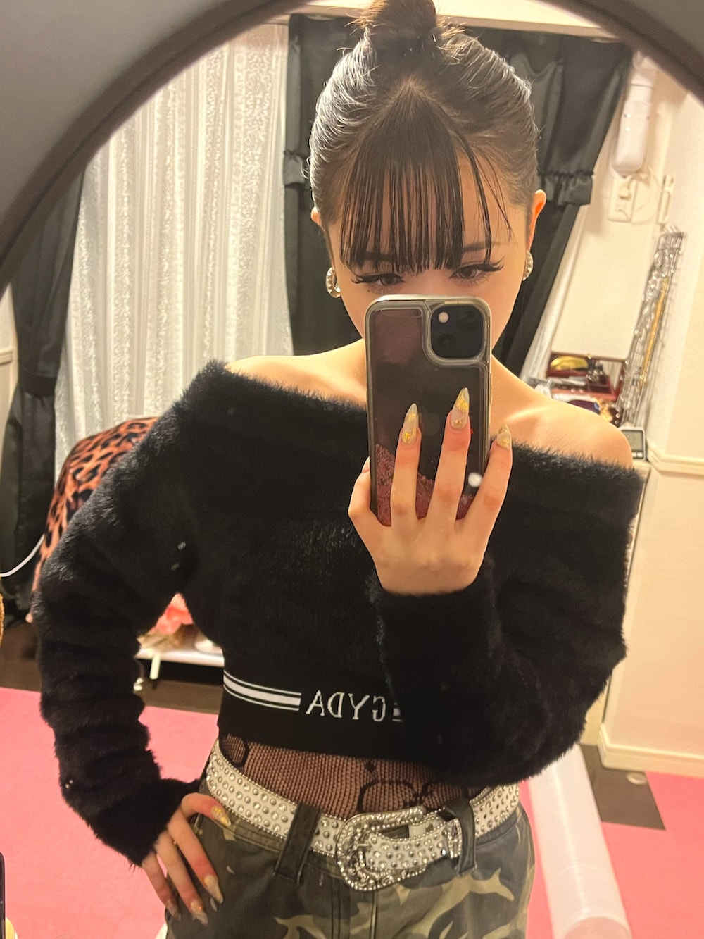 ブラック系のニット/セーター、ホワイト系のスニーカー、シルバー系のピアス（両耳用）を着用したレディースの冬コーディネートの2枚目の写真