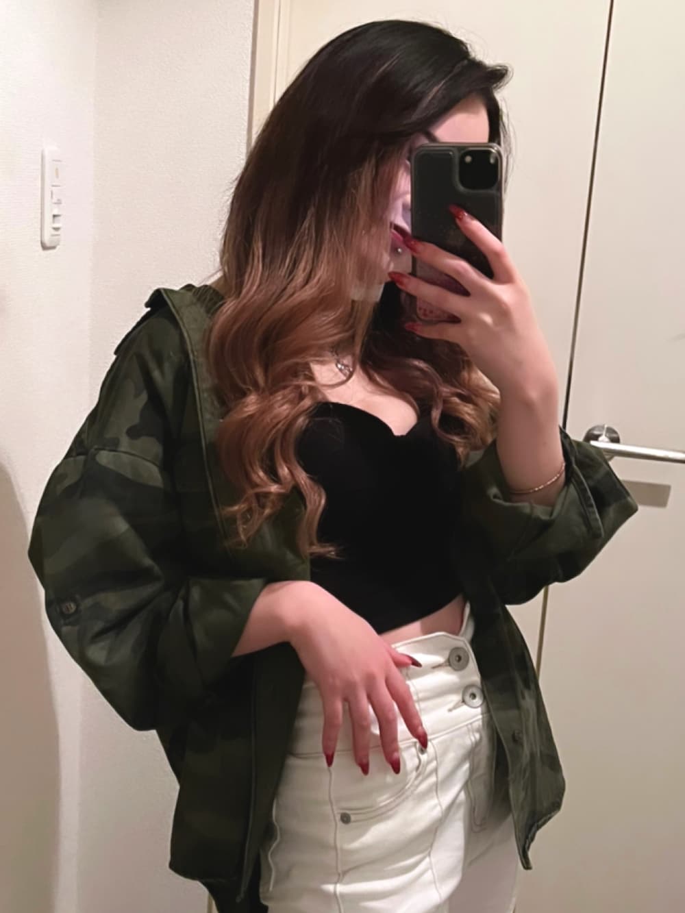 ホワイト系のデニムパンツ、ブラック系のチューブトップ、グリーン系のシャツ/ブラウスを着用したレディースの秋コーディネートの2枚目の写真