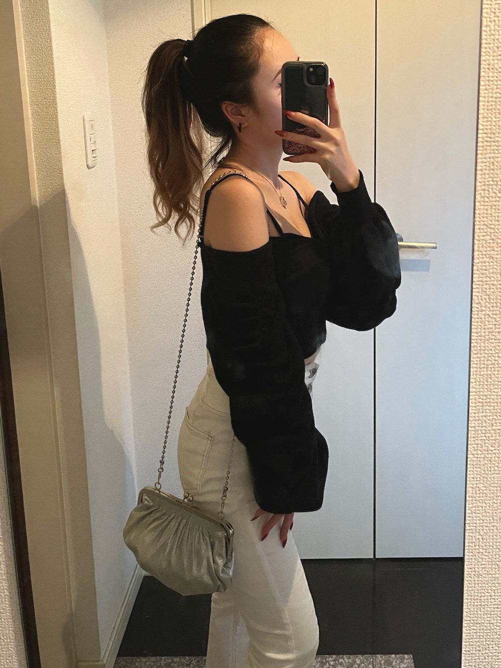 ブラック系のニット/セーター、ホワイト系のデニムパンツ、ブラック系のチューブトップを着用したレディースの秋コーディネートの2枚目の写真