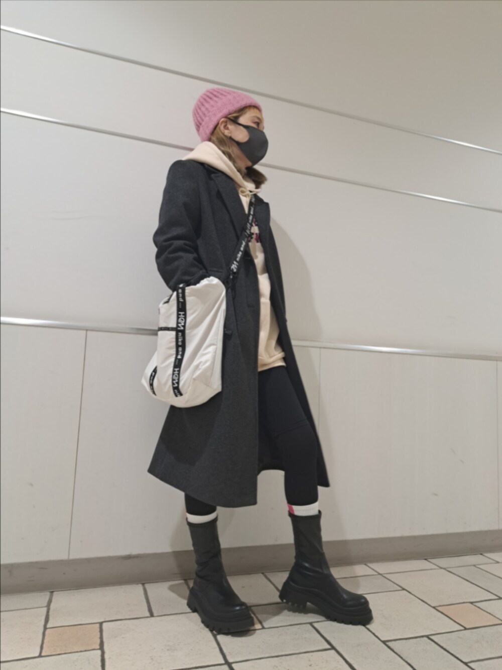 グレー系のジャケット/アウター、ブラック系のブーツ、ホワイト系のバッグを着用したレディースの冬コーディネートの2枚目の写真