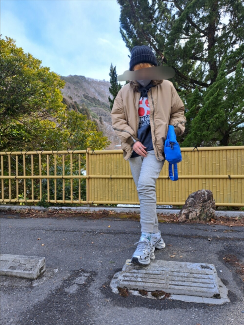 ベージュ系のジャケット/アウター、ブルー系のバッグ、グレー系のパンツを着用したレディースの冬コーディネートの2枚目の写真