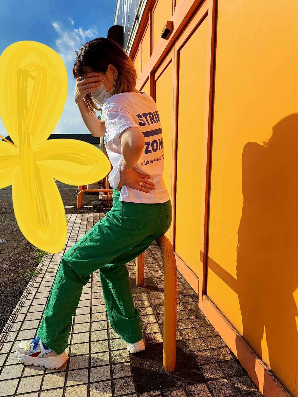 グリーン系のチノパンツを着用したレディースの夏コーディネートの2枚目の写真