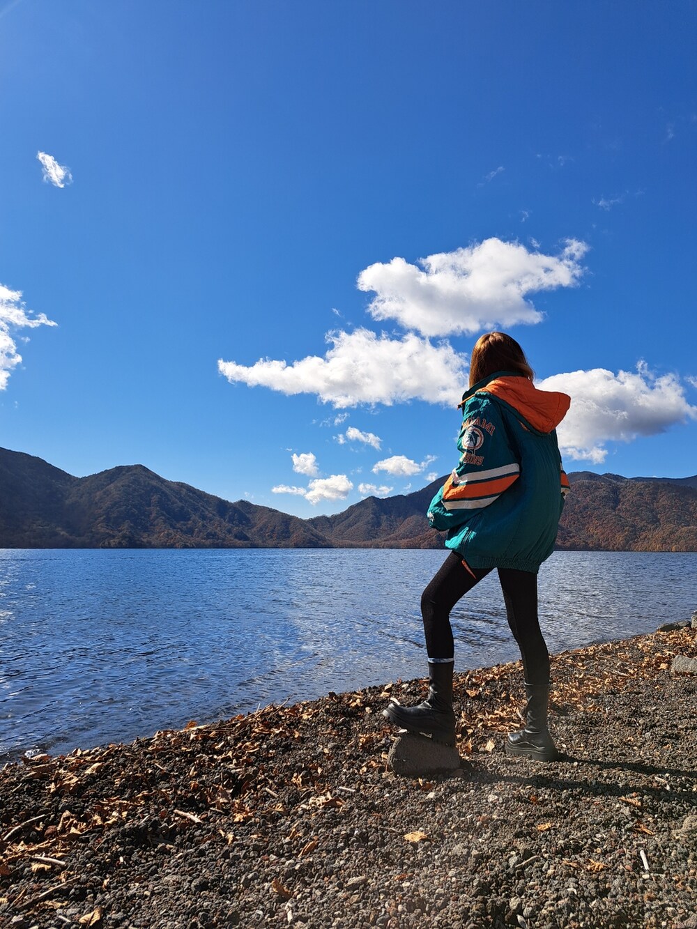 ブラック系のその他パンツ、ブラック系のブーツ、ブルー系のショルダーバッグを着用したレディースの秋コーディネートの3枚目の写真