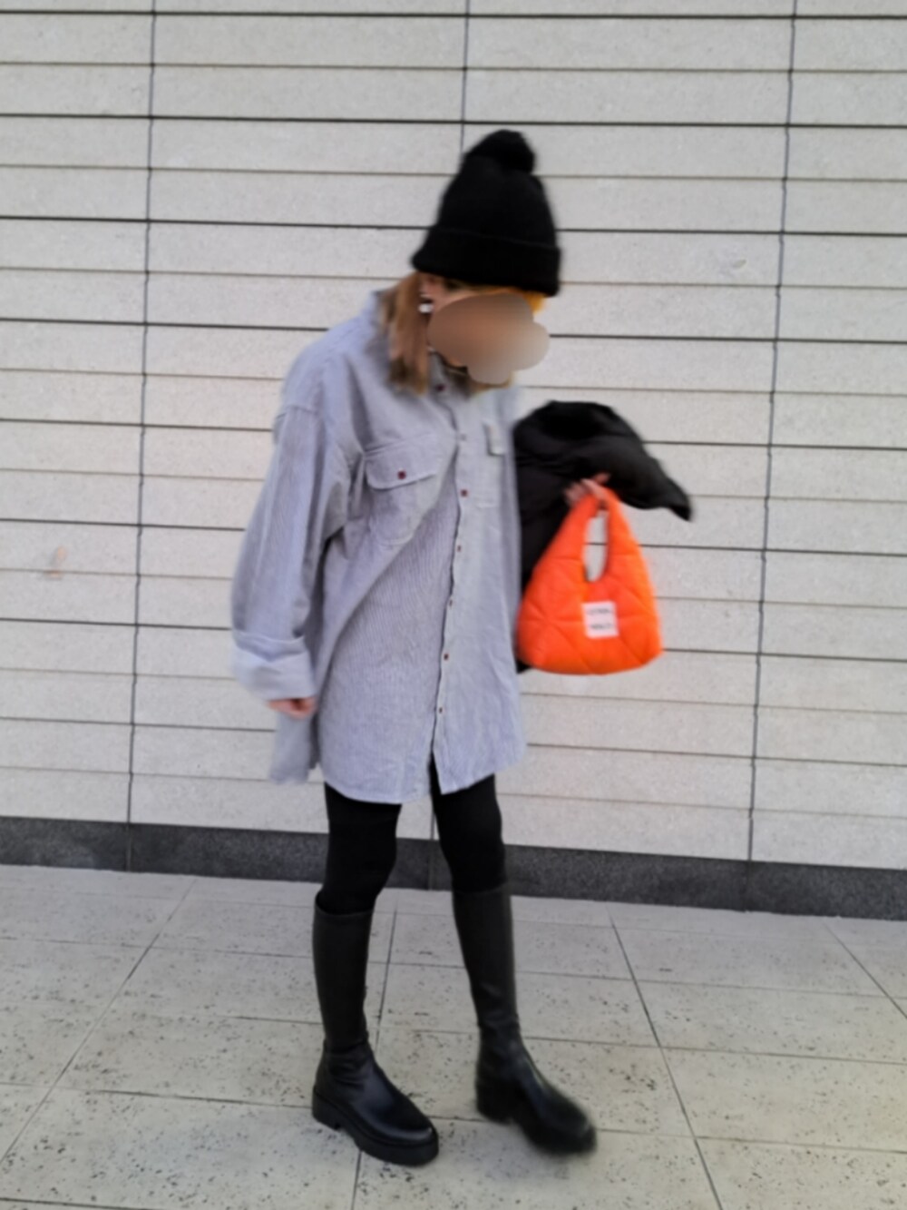 オレンジ系のバッグ、ブラック系のブーツ、ブルー系のシャツ/ブラウスを着用したレディースの冬コーディネートの2枚目の写真