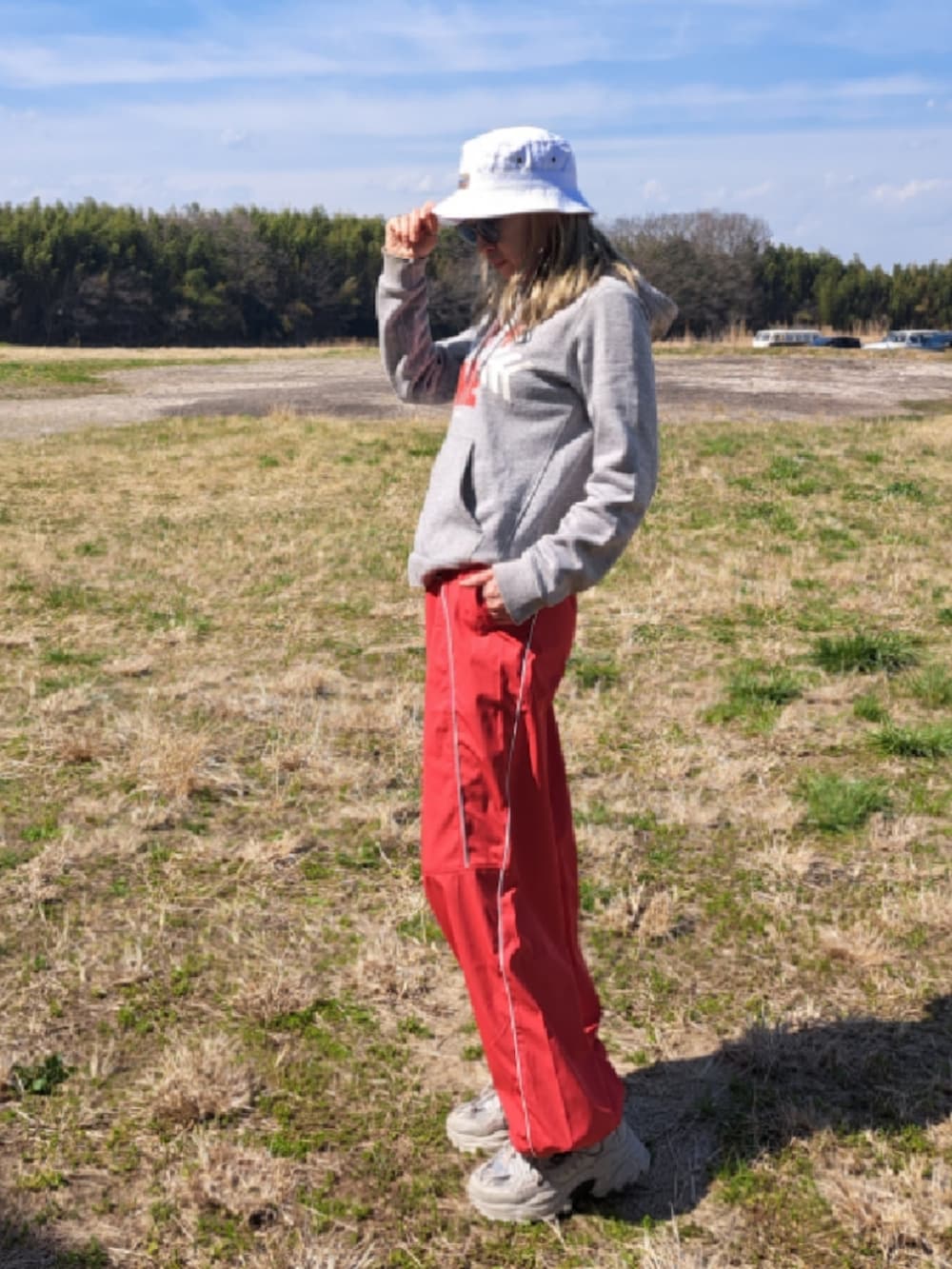 グレー系のパーカー、ホワイト系のキャスケットを着用したレディースの春コーディネートの2枚目の写真