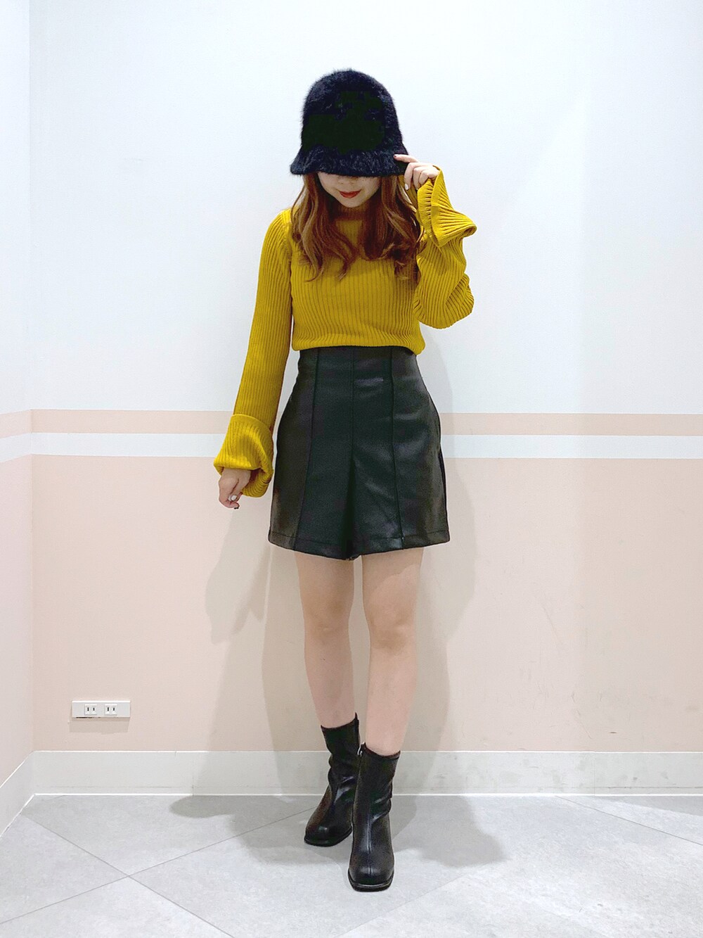 イエロー系のニット/セーター、ブラック系のその他パンツ、ブラック系のブーツを着用したレディースの秋コーディネートの2枚目の写真