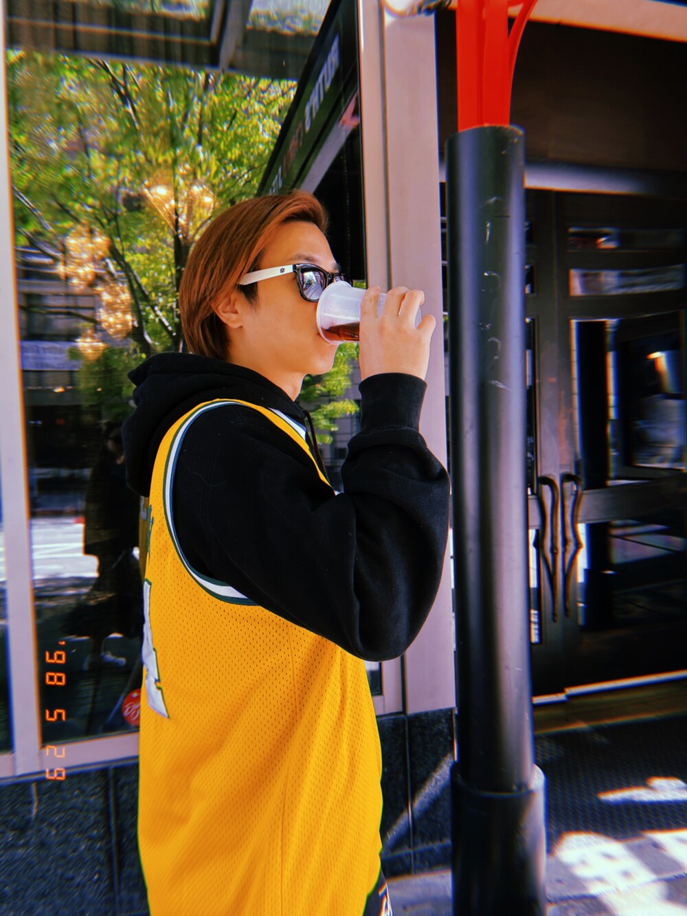 イエロー系のジャージ、ブラック系のパーカー、ブラック系のカーゴパンツを着用したメンズの夏コーディネートの4枚目の写真