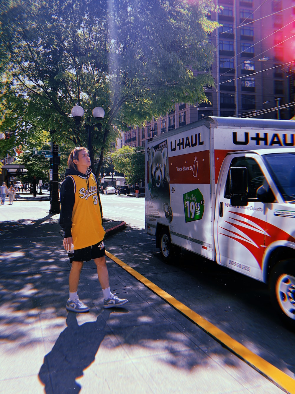 イエロー系のジャージ、ブラック系のパーカー、ブラック系のカーゴパンツを着用したメンズの夏コーディネートの2枚目の写真