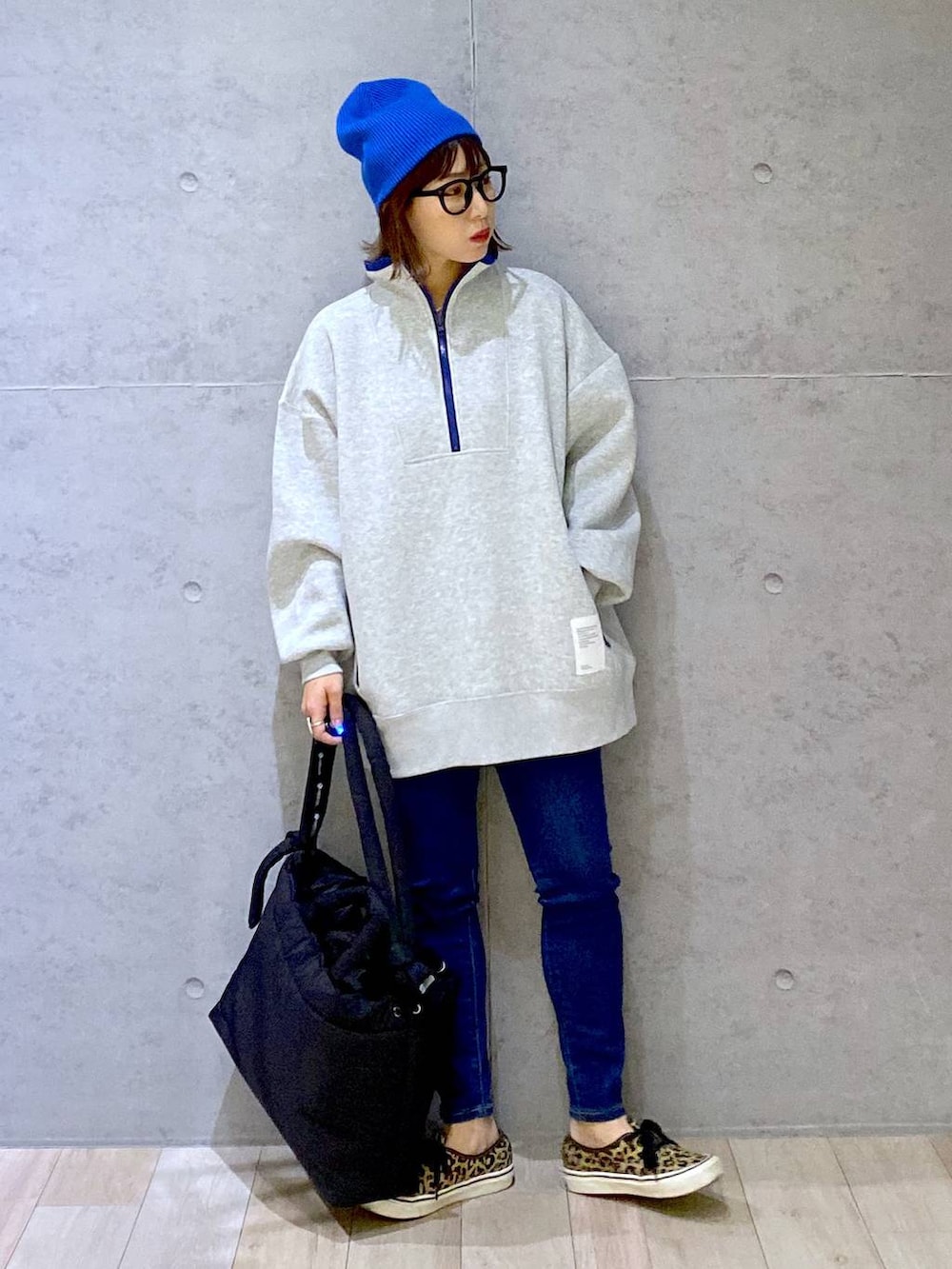 グレー系のTシャツ/カットソー、ブルー系のデニムパンツ、ブラック系のマザーズバッグを着用したレディースの冬コーディネートの5枚目の写真