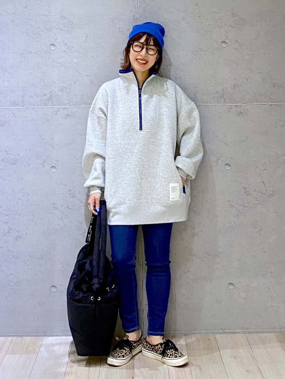 グレー系のTシャツ/カットソー、ブルー系のデニムパンツ、ブラック系のマザーズバッグを着用したレディースの冬コーディネートの4枚目の写真