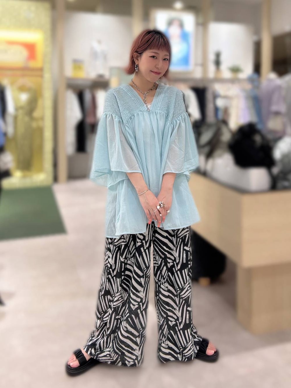 ブラック系のその他パンツ、ブラック系のサンダル、ブルー系のシャツ/ブラウスを着用したレディースの春コーディネートの2枚目の写真