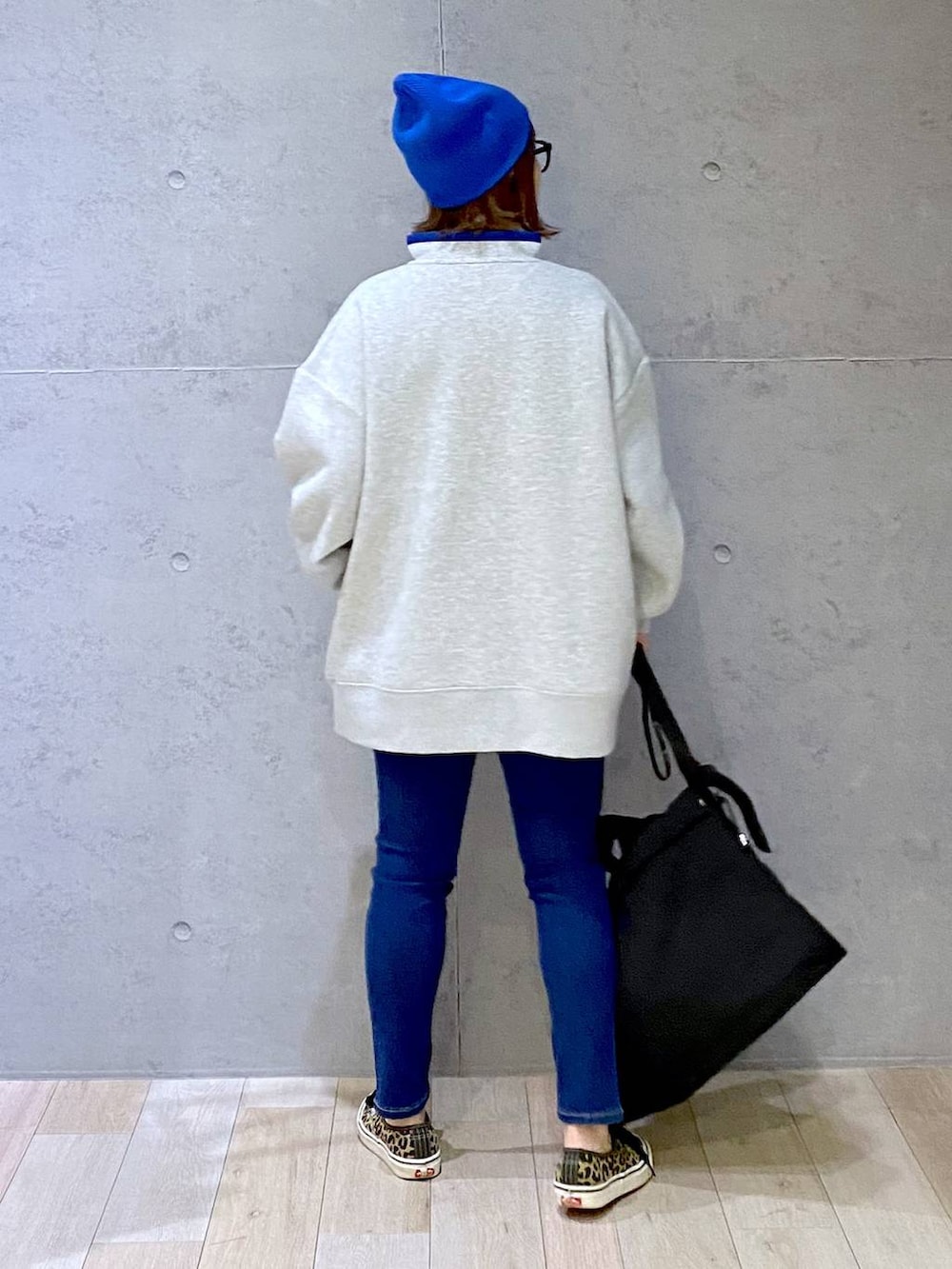 グレー系のTシャツ/カットソー、ブルー系のデニムパンツ、ブラック系のマザーズバッグを着用したレディースの冬コーディネートの2枚目の写真