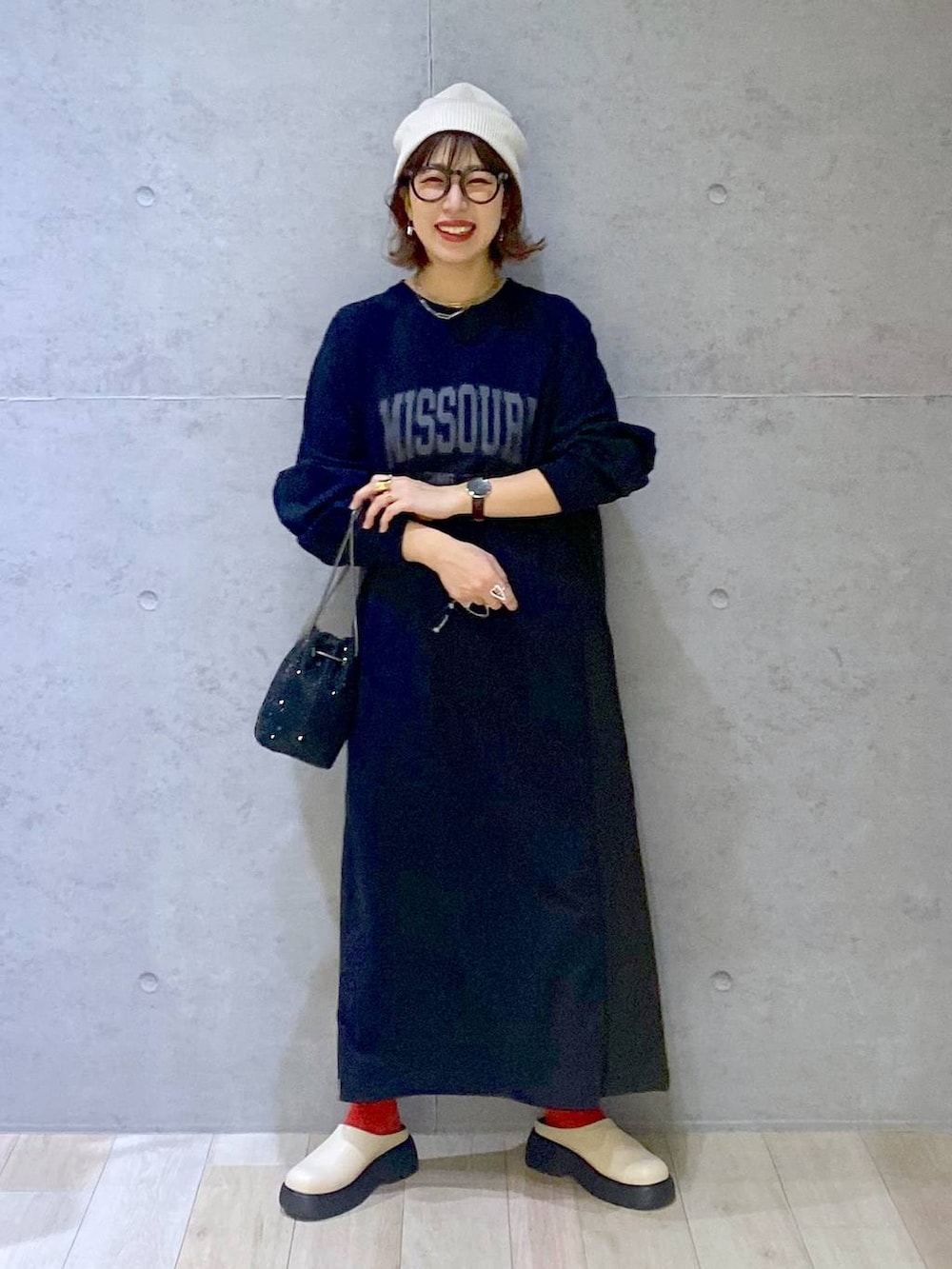 ブラック系のショルダーバッグ、ホワイト系のその他シューズ、ブラック系のワンピースを着用したレディースの春コーディネートの2枚目の写真