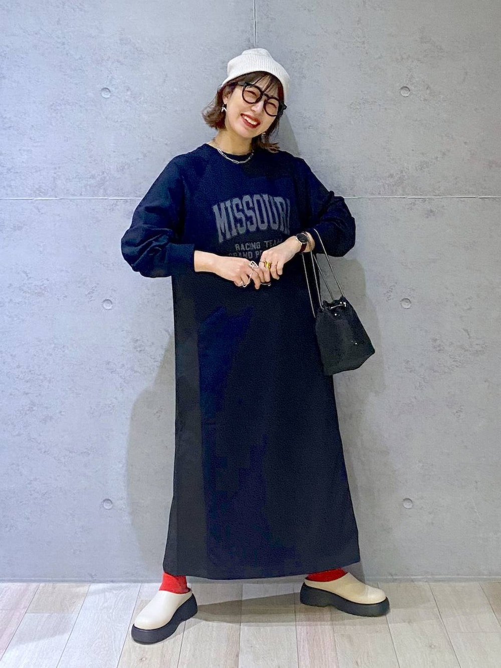 ブラック系のショルダーバッグ、ホワイト系のその他シューズ、ブラック系のワンピースを着用したレディースの春コーディネートの5枚目の写真