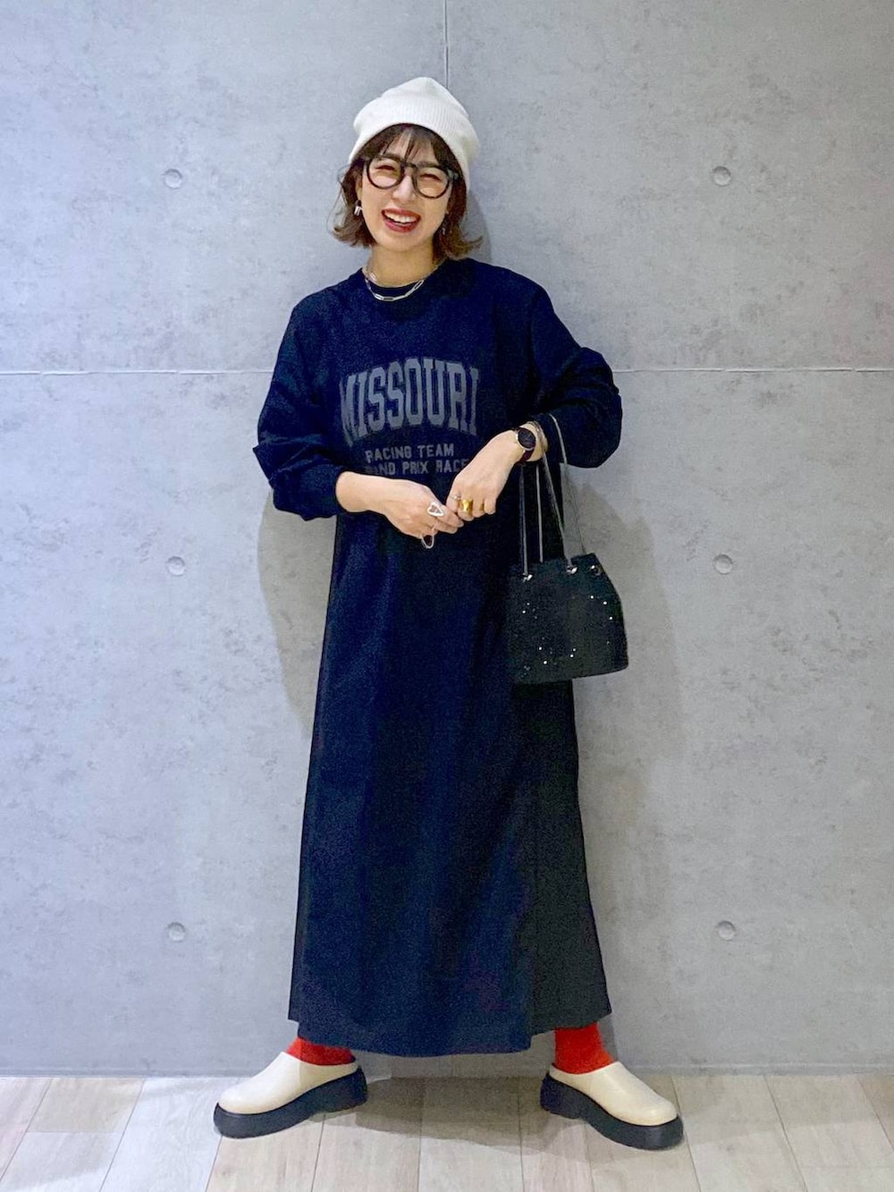 ブラック系のショルダーバッグ、ホワイト系のその他シューズ、ブラック系のワンピースを着用したレディースの春コーディネートの6枚目の写真