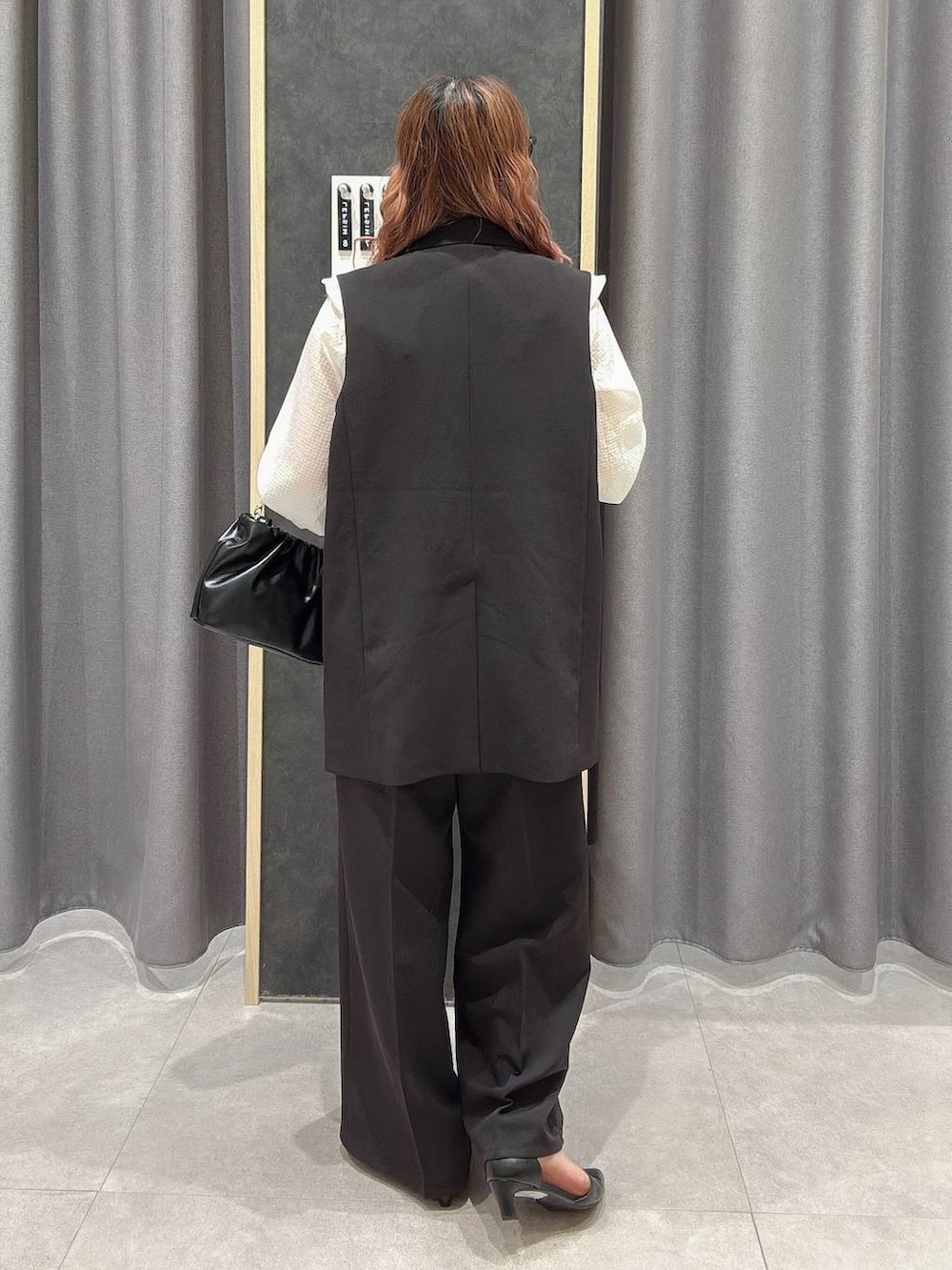 ブラック系のサロペット/オーバーオール、ブラック系のその他アウター、ホワイト系のシャツ/ブラウスを着用したレディースの冬コーディネートの2枚目の写真