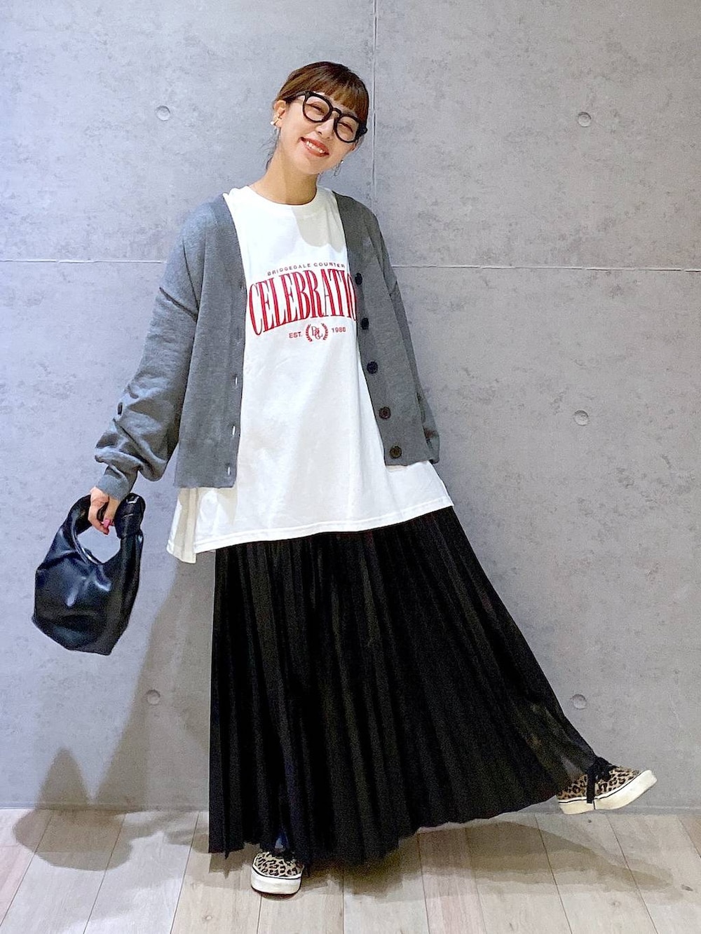 グレー系のカーディガン/ボレロ、ブラック系のスカート、ホワイト系のマタニティウェア/グッズを着用したレディースの秋コーディネートの2枚目の写真