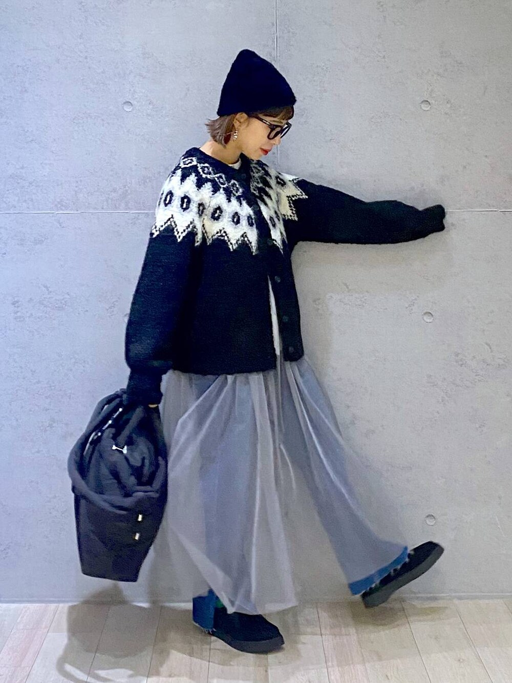 ブルー系のデニムパンツ、ブラック系のモカシン/デッキシューズ、グレー系のワンピースを着用したレディースの冬コーディネートの2枚目の写真