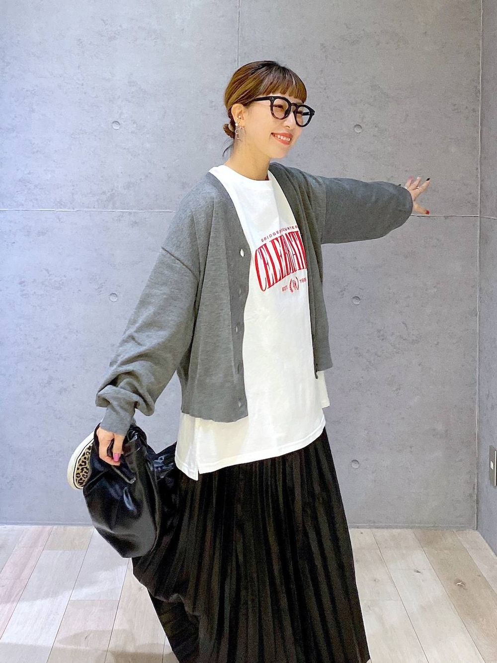 グレー系のカーディガン/ボレロ、ブラック系のスカート、ホワイト系のマタニティウェア/グッズを着用したレディースの秋コーディネートの4枚目の写真