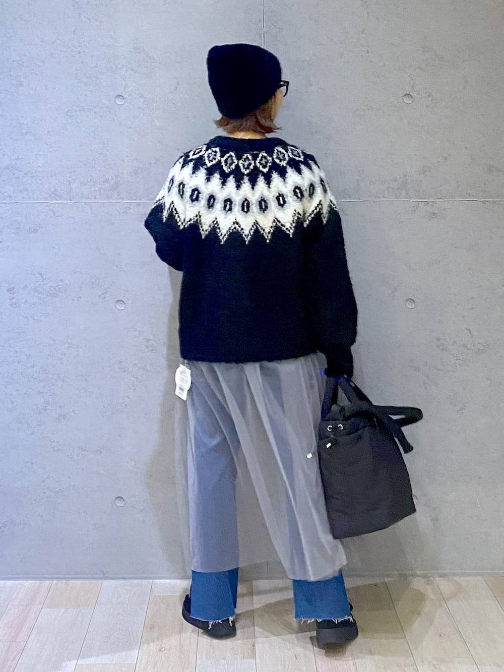 ブルー系のデニムパンツ、ブラック系のモカシン/デッキシューズ、グレー系のワンピースを着用したレディースの冬コーディネートの3枚目の写真