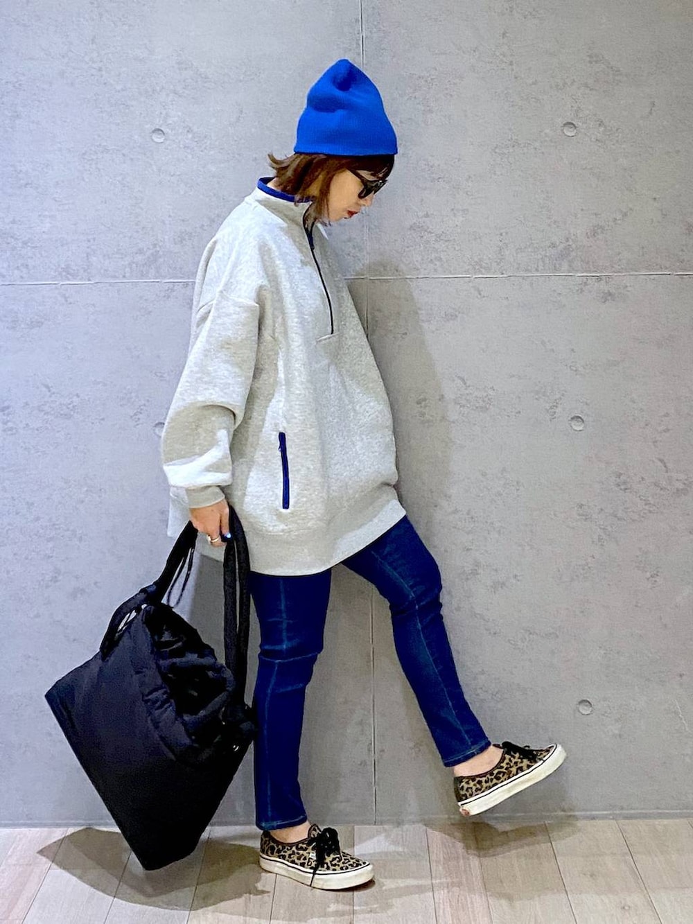 グレー系のTシャツ/カットソー、ブルー系のデニムパンツ、ブラック系のマザーズバッグを着用したレディースの冬コーディネートの3枚目の写真