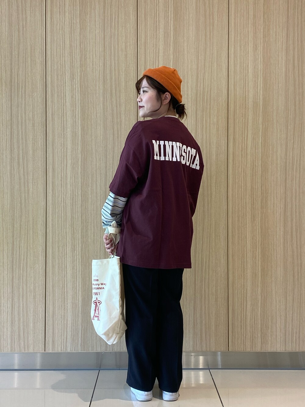 ベージュ系のTシャツ/カットソー、ベージュ系のトートバッグ、ブラウン系のTシャツ/カットソーを着用したレディースの春コーディネートの2枚目の写真