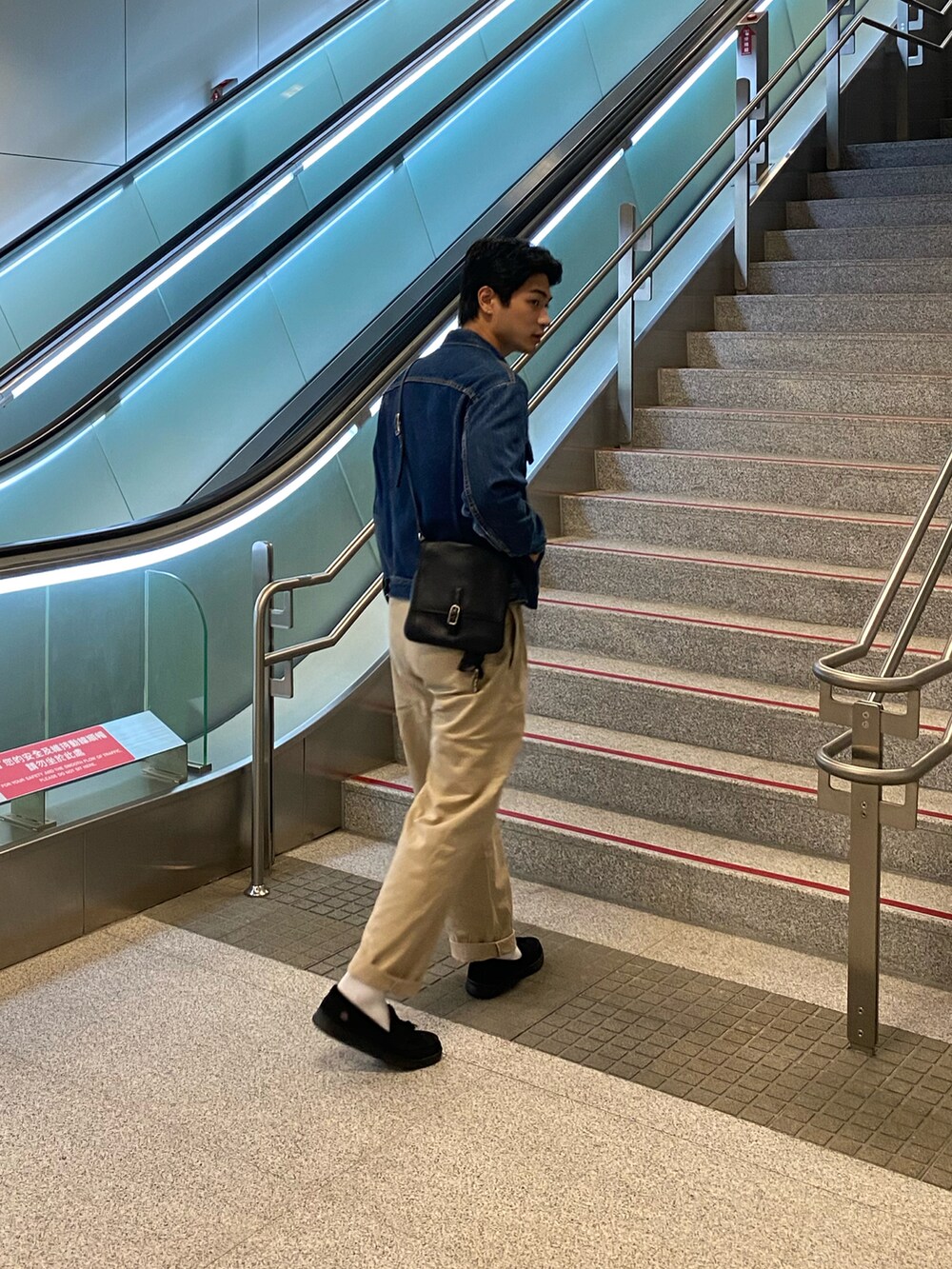 ブルー系のデニムジャケット、ベージュ系のチノパンツ、ブラック系のローファーを着用したメンズの秋コーディネートの2枚目の写真