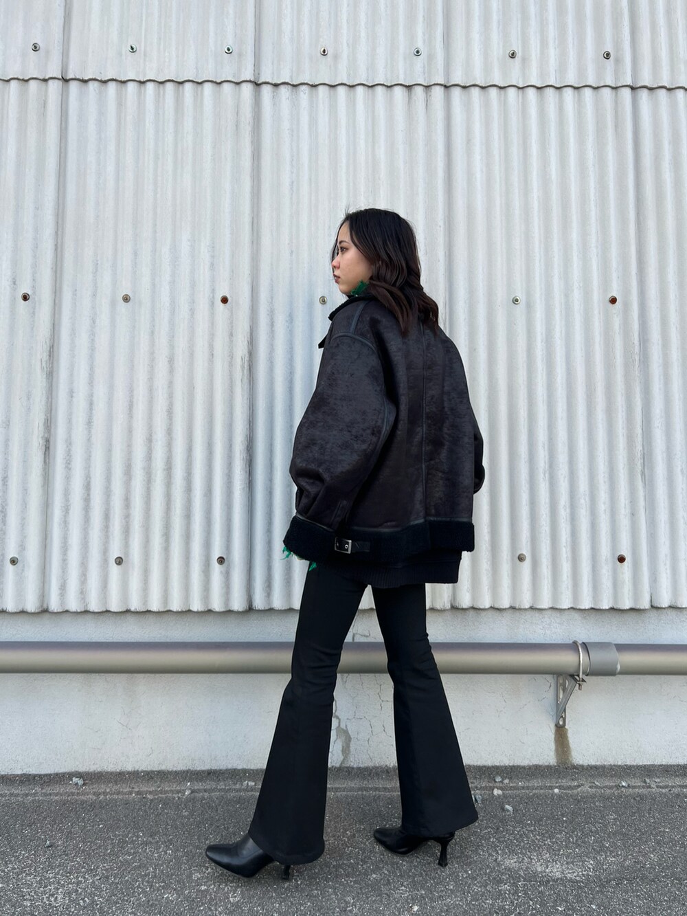 ブラック系のブルゾン、グリーン系のニット/セーター、ブラック系のスウェットを着用したレディースの冬コーディネートの3枚目の写真