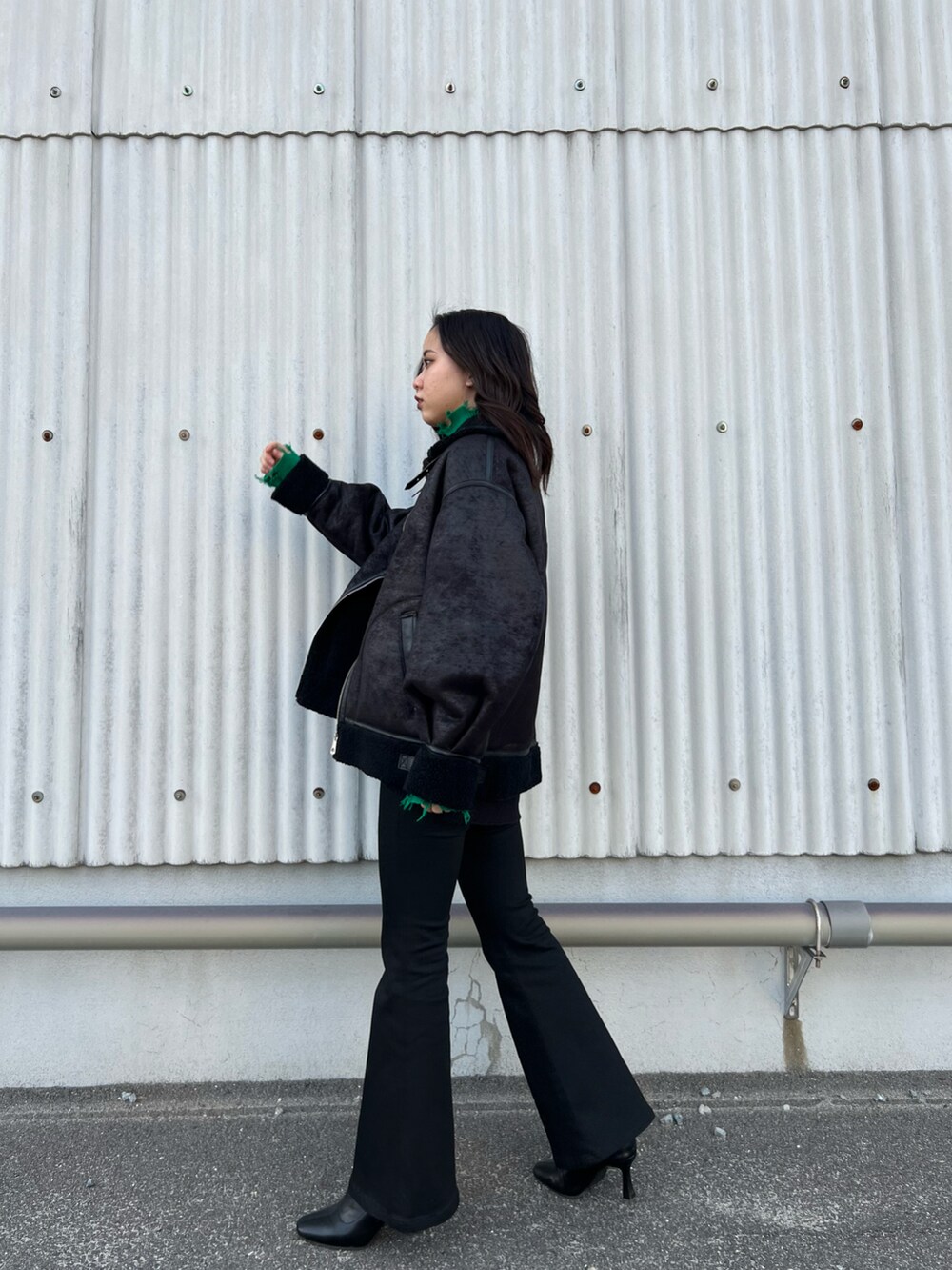 ブラック系のブルゾン、グリーン系のニット/セーター、ブラック系のスウェットを着用したレディースの冬コーディネートの2枚目の写真