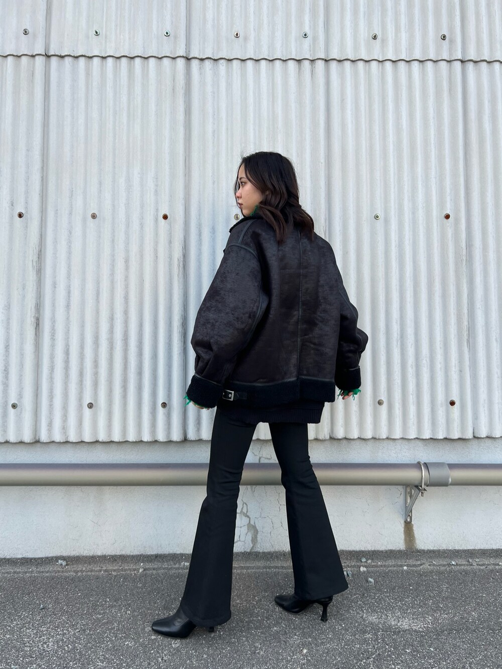 ブラック系のブルゾン、グリーン系のニット/セーター、ブラック系のスウェットを着用したレディースの冬コーディネートの4枚目の写真
