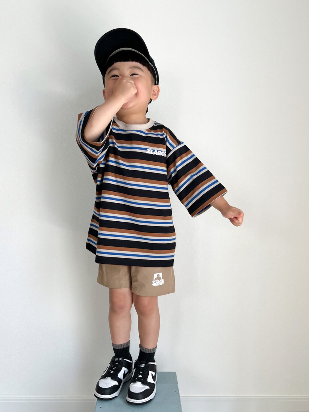 ブラック系のTシャツ/カットソー、ベージュ系のその他パンツ、ホワイト系のスニーカーを着用したキッズの春コーディネートの2枚目の写真