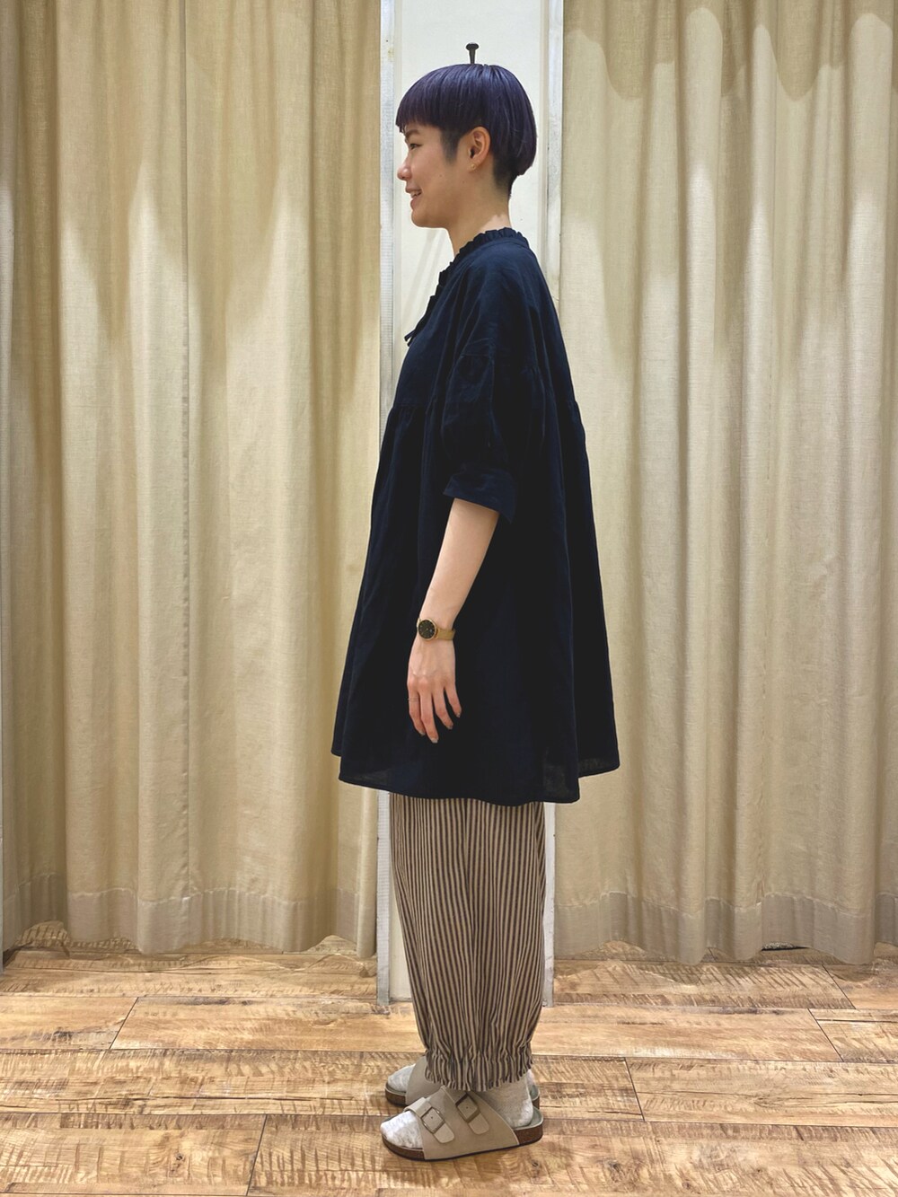 ブラック系のチュニック、ベージュ系のその他パンツ、ベージュ系のハンドバッグを着用したレディースの夏コーディネートの2枚目の写真