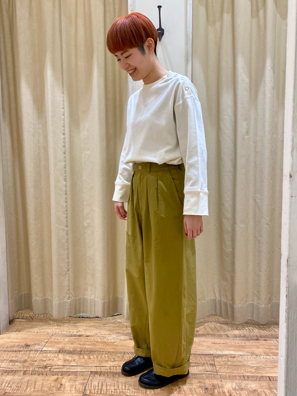 ホワイト系のトップス、イエロー系のパンツを着用したレディースの冬コーディネートの2枚目の写真