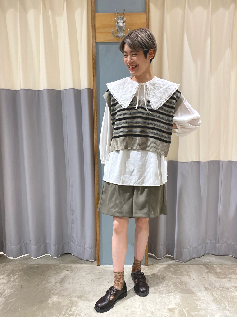 ブラック系のベスト、グリーン系のその他パンツ、ホワイト系のシャツ/ブラウスを着用したレディースの秋コーディネートの2枚目の写真