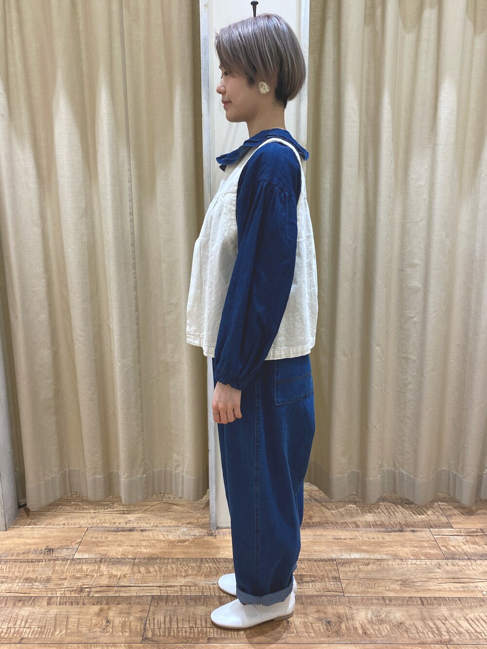 ホワイト系のベスト、ブルー系のシャツ/ブラウス、ブルー系のデニムパンツを着用したレディースの春コーディネートの2枚目の写真