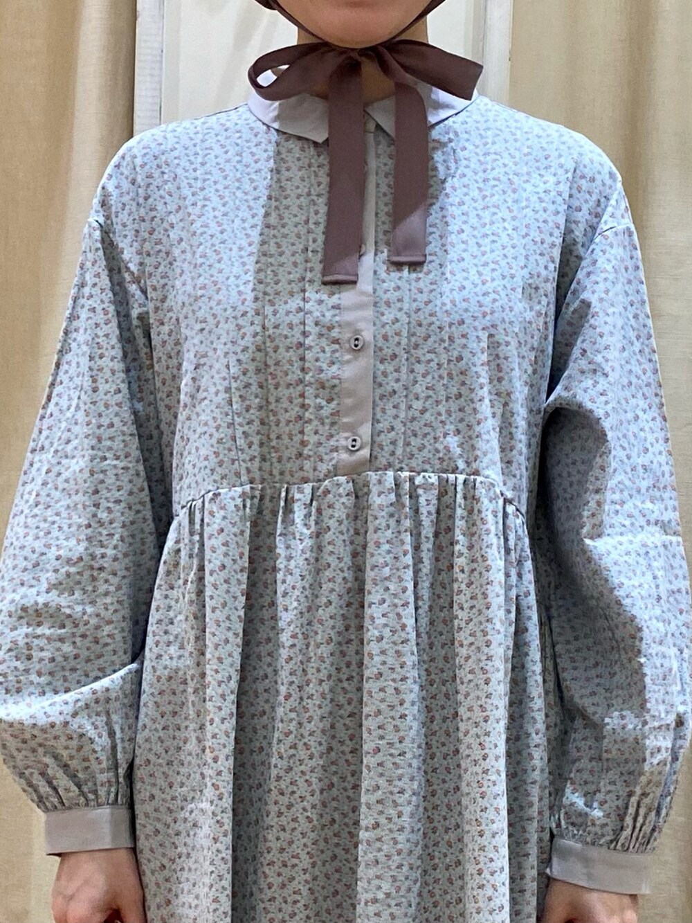 グリーン系のワンピース/ドレス、ベージュ系のドレスシューズ、ブラウン系のハットを着用したレディースの冬コーディネートの3枚目の写真