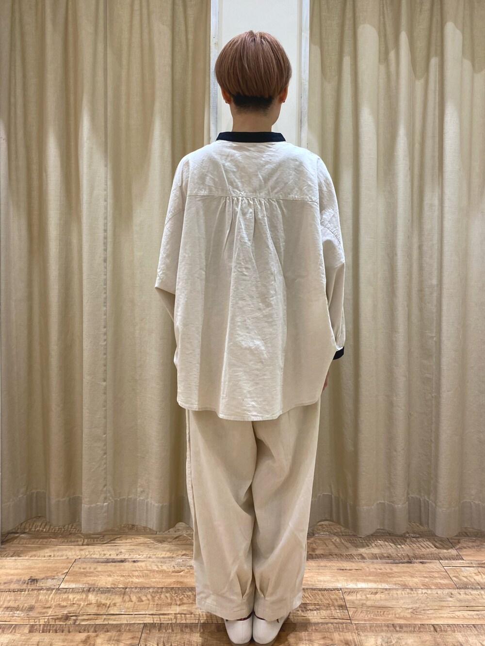 ベージュ系のシャツ/ブラウス、ホワイト系のその他パンツ、ブラック系のハンドバッグを着用したレディースの春コーディネートの3枚目の写真