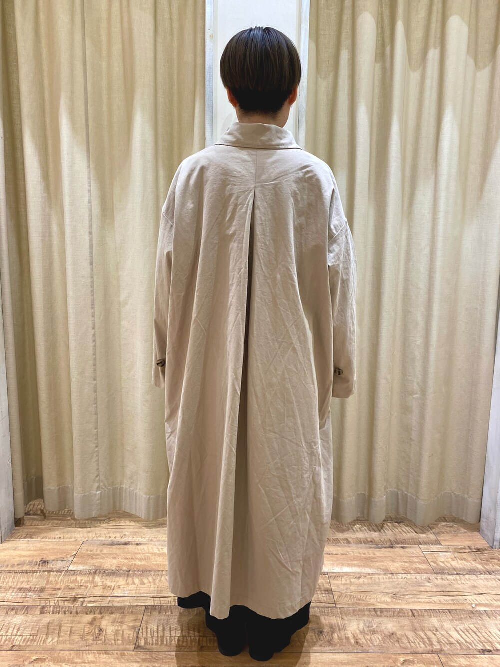 ベージュ系のステンカラーコート、ブラック系のその他シューズ、ブラック系のショルダーバッグを着用したレディースの秋コーディネートの4枚目の写真